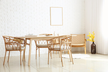 Interior of dining room with modern furniture near white brick wall