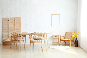 Interior of dining room with modern furniture near white brick wall
