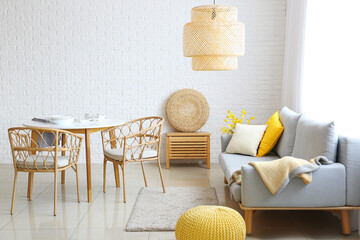 Stylish interior of living room with comfortable sofa and dining table near white brick wall © Pixel-Shot