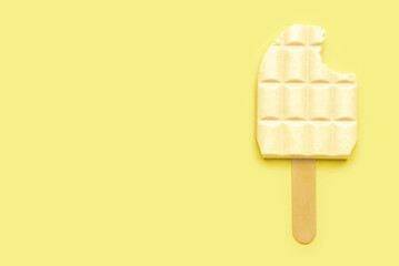 White chocolate bar and ice cream stick on color background
