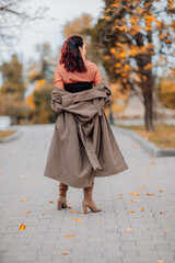 A woman walks outdoors in autumn, enjoys the autumn weather.