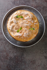 Polish Carpathian Mountain Cream Cake Karpatka closeup on the plate on the table. Vertical top view from above