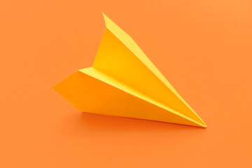 Yellow paper plane on orange background