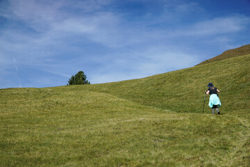 Obraz premium Young sporty hiker woman is hiking in the italian dolomites and enyos nature. travel and holiday concept.