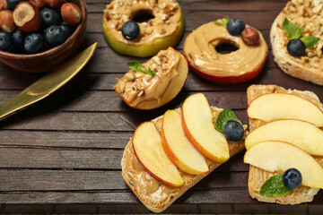 Wooden board of tasty sandwiches with nut butter and apples, closeup