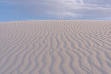 Fototapeta na wymiar Cloudy blue sky over the ripple white dunes of White Sands National Park, sand dunes and sky