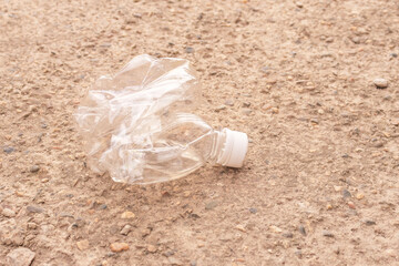 a small crushed water bottle on the ground