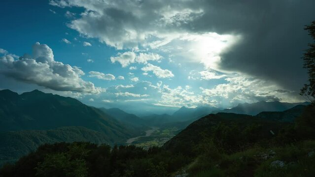 Time lapse of cloud movement and god rays at top of Monte Dobis, panoramic view of Carnic Alps and Val Canale in distance; Udine, Italy