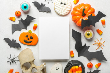 Composition with blank card and Halloween decor on light background