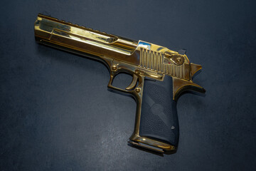 A firearm, a large gold-colored pistol.