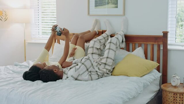 Black couple, bedroom and selfie holding digital camera in pajamas for morning picture for marriage honeymoon in hotel bedroom. Man and woman on bed to relax, love and capture holiday memory