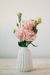 Beautiful pink bouquet of flowers in the vase on the table. Cozy home decoration and festive decor