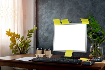 a computer with blank screen, lamp, plant, organizer and glasses, cup, mouse, three datebooks and pencils,  Front view. Concept of work.