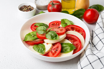 Caprese salad made of sliced fresh tomatoes, mozzarella cheese and basil.