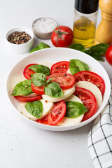 Caprese salad made of sliced fresh tomatoes, mozzarella cheese and basil.