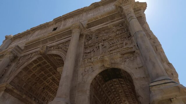 Looking Up At Arch of Septimius Severus Against Sunny Clear Blue Skies. Pan Left