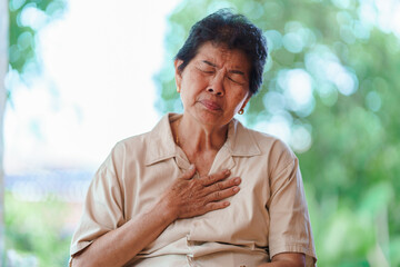 Elderly women with chest pain and wheezing Caused by shock or regret. Concept of health problems in...