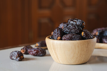 Medjool dates in a wooden container on the table. It is the king of dates with the largest size.