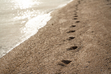 Fototapeta na wymiar Human footprint on sand summer beach background with copyspace