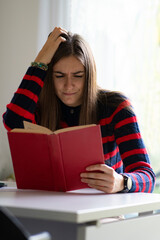 Dyslexic adult girl concept. Difficulty in reading book. - obrazy, fototapety, plakaty