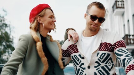 Beautiful young adult couple kissing and sitting in car. Lovers in orange cabriolet. Autunm and romantic concept.
