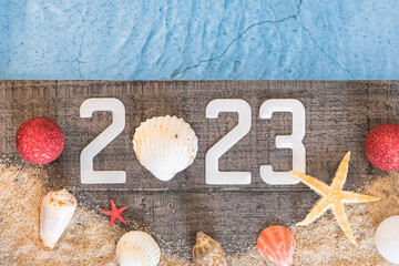 Concept de bonne année 2023 avec des coquillages et une étoile de mer au bord d'une piscine....