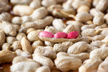 Pink peanuts on peanuts pile background.