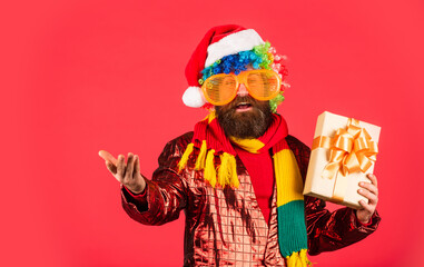 Fototapeta na wymiar excited by xmas prices hurry shopping. Photo of mature handsome man holding christmas gift boxes. Merry Christmas and Happy New Year. brutal bearded santa male red background. Look at that