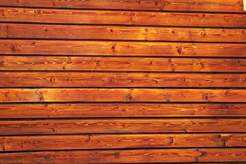 background or texture for your site or product. photograph of a wooden wall made of planed clapboard in the rays of bright sunlight.