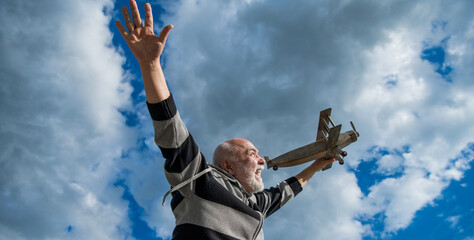 elderly senior retired man. mature man at retirement. old man on sky background with toy plane
