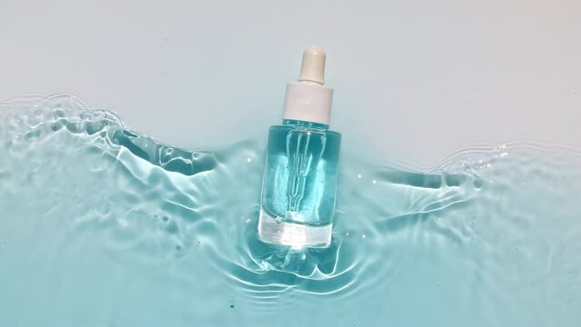 Cosmetic bottle, vial for oil, liquid, collagen serum on water surface with drops. Women's cosmetics skincare. Sample of layout, advertising of a beauty product. High quality 4k footage