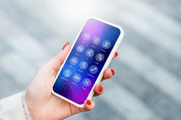 woman with mobile phone reading astrological forecast about zodiac signs