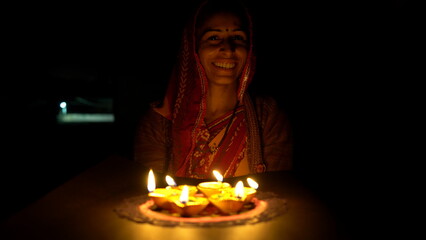 Indian Festival Diwali. Indian girl holding diya for Diwali. girl holding lit diya lamp in hands,...