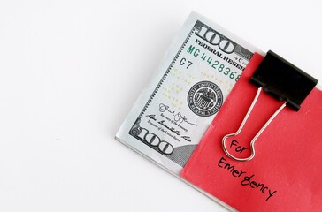 Cash dollar money with red handwritten stick note EMERGENCY BUDGET, smart financial planning to...