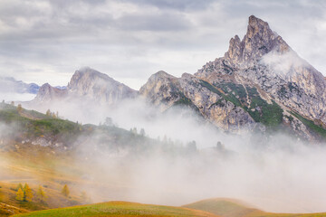 Mountain range in the morning fog, yellow autumn shades. The Dolomites, also known as the Dolomite Mountains, Dolomite Alps or Dolomitic Alps, are a mountain range located in northeastern Italy.