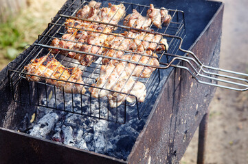 Tasty chicken wings cooking on barbecue grill, outdoors. Roasted chicken meat, closeup