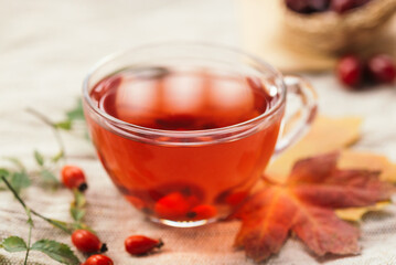 A cup of rose hip tea with fresh berries in a glass cup. Vintage background, selective focus