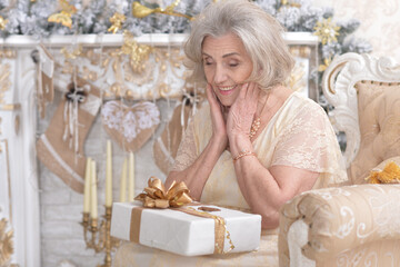 Obraz na płótnie Canvas Elderly woman in a room with New Year's decor