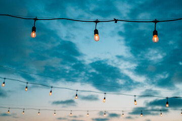 outdoor string lights in sunset sky
