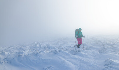 A woman in the winter trekking during the fog