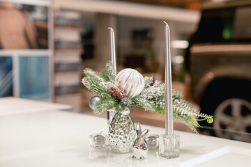 Christmas decoration of a car dealership. New Year's car sale. Silver Christmas decorations and tinsel. Festive mood in the business center. Toy rabbit. Symbol of the year 2023