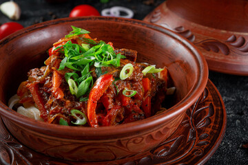 Traditional Kazakh dish Kuirdak. Aromatic roast of by-products, lamb meat with lots of onions and vegetables in a clay pot