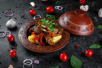 Fototapeta na wymiar Traditional Kazakh dish Kuirdak. Aromatic roast of by-products, lamb meat with lots of onions and vegetables in a clay pot