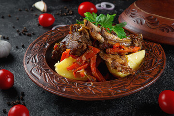 Traditional Kazakh dish Kuirdak. Aromatic roast of by-products, lamb meat with lots of onions and vegetables in a clay pot