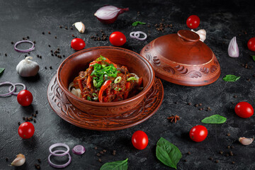 Traditional Kazakh dish Kuirdak. Aromatic roast of by-products, lamb meat with lots of onions and vegetables in a clay pot