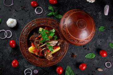 Traditional Kazakh dish Kuirdak. Aromatic roast of by-products, lamb meat with lots of onions and vegetables in a clay pot