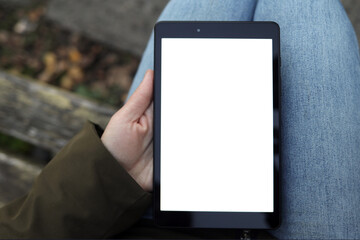 woman holds a tablet in her hands with a white, blank screen for design, copy space