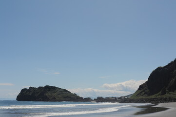 Picturesque seashore with rocks and beach on a sunny day with clear blue sky and calm ocean on Hokkaido, northern Japan, Asia