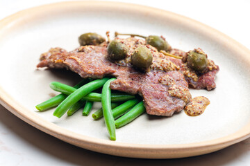 pork steak with mustard sauce with capers served with green beans