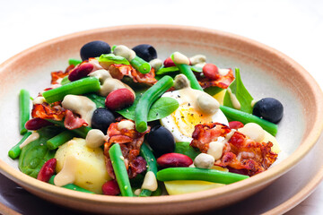 salad of green and red beans with black olives, spinach, boiled egg and bacon